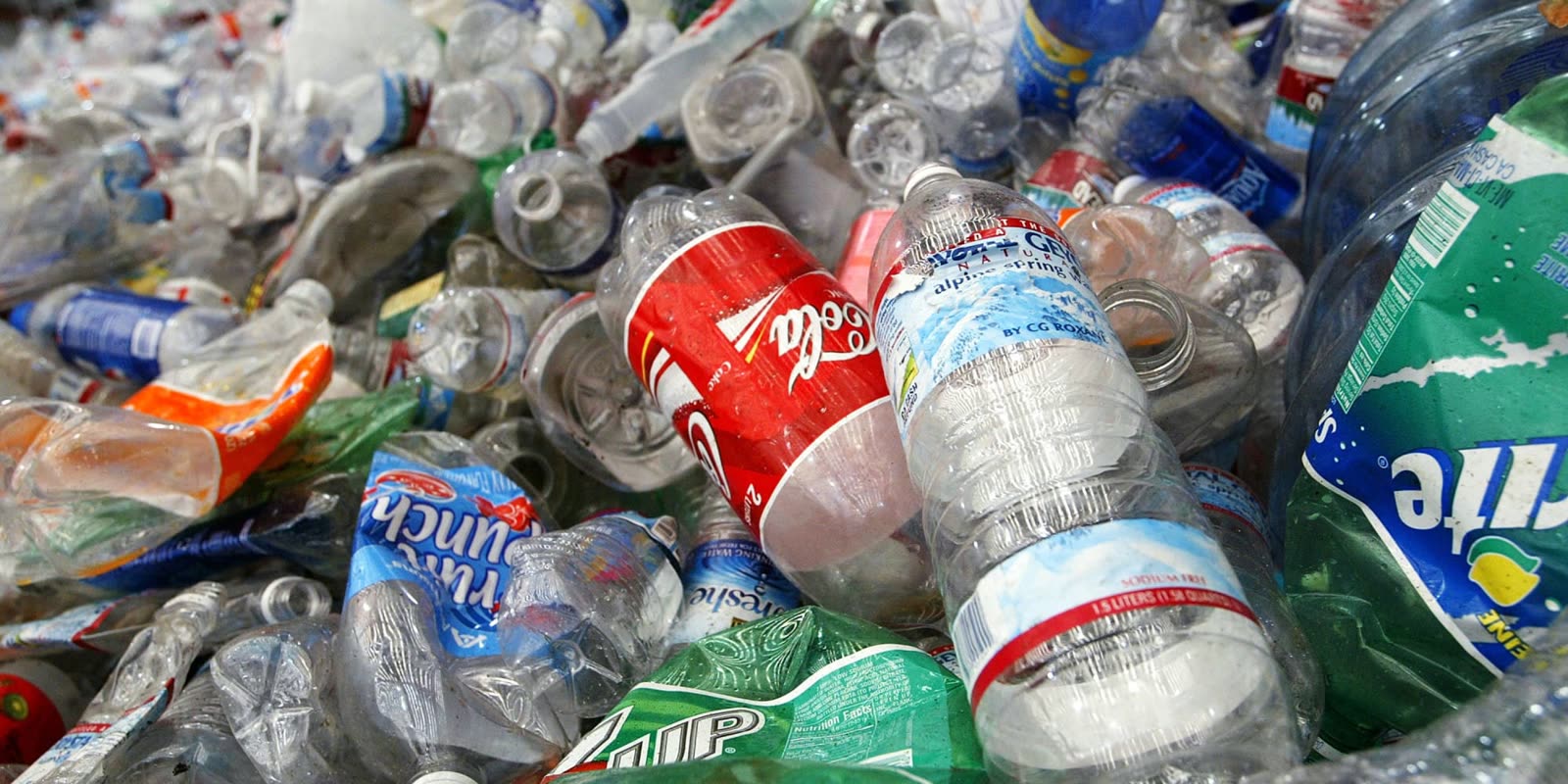 Crushed PET bottles with faded labels and caps piled together